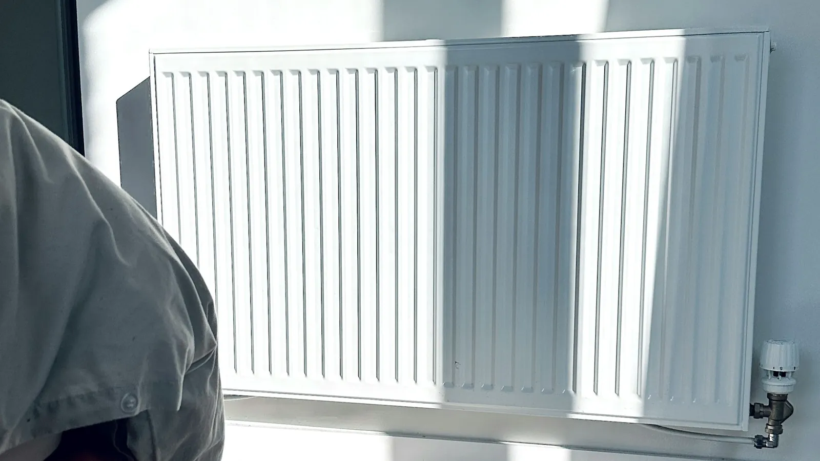 Heizkörper unter einem Fenster, Sonnenlicht fällt in den Raum